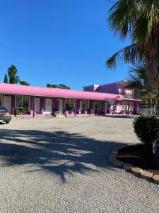 天鹅山明轮船汽车旅馆的粉红色建筑前的停车场
