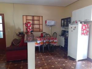 戈亚斯州上帕莱索Casa azul的厨房配有桌子和白色冰箱。