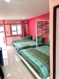 锡春At Sichon Home By At Sichon Resort的配有粉红色墙壁的客房内的两张床