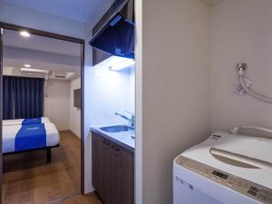 那霸Living Inn Asahibashiekimae Premier的一间带水槽、床和镜子的浴室