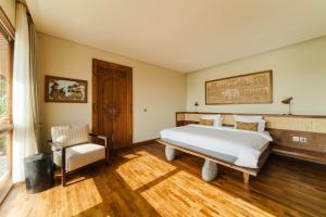 坎古Villa Uma Berawa by Nakula的卧室配有一张白色大床和一把椅子