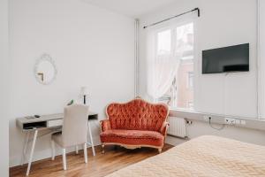 斯卡拉Järnvägshotellet B& B i Skara的一间卧室配有椅子、书桌和电视