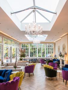 科克Cork's Vienna Woods Hotel & Villas的大房间设有紫色椅子和吊灯