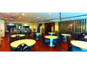 坤甸坤甸梅尔帕提酒店的一间带桌椅的餐厅和一间酒吧