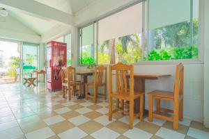 班武里府OYO 614 Koh Lak Resort的用餐室设有桌椅和窗户。