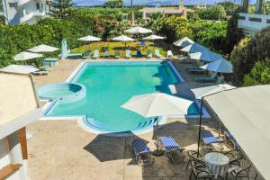 克雷马斯蒂瓦伦蒂诺酒店的一个带遮阳伞和椅子的游泳池以及一个游泳池