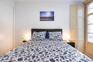 马拉加Apartamento Soho Málaga的一间卧室配有一张带蓝色和白色床单的床。