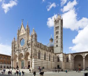锡耶纳Suite al Duomo的一座大建筑,前面有一个钟楼