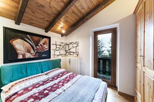 普雷托罗Chalet Mirastelle的一间卧室设有一张床和一个大窗户
