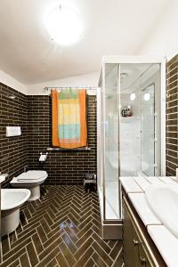普雷托罗Chalet Mirastelle的一间带两个盥洗盆、淋浴和两个卫生间的浴室