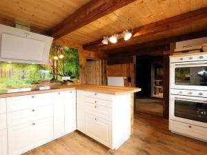 布莱特瑙Ferienhütte Biobetrieb Lippenhof的厨房配有白色橱柜和木制天花板