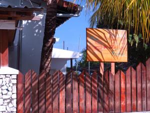 呼拉乎拉日出酒店的棕榈树旁的红色栅栏,上面有画