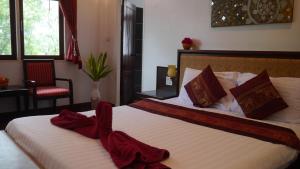 Sathing Phra敖泰度假酒店的一间卧室配有两张带红色毛巾的床。