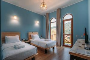 VarjanisiHotel Chateau Iveri的配有两张床铺的蓝色墙壁和窗户