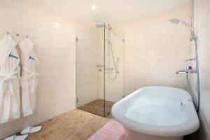 万塔哈梅库兰庄园酒店的带淋浴和白色浴缸的浴室