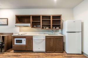 桑福德WoodSpring Suites Sanford North I-4 Orlando Area的厨房配有白色冰箱和木制橱柜。