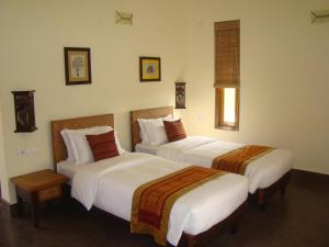 KumguriMusa Jungle Retreat的一间酒店客房,房间内设有两张床