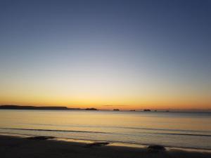 韦茅斯海浪旅馆的日落在海滩上与大海