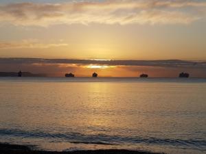 韦茅斯海浪旅馆的海上日落,水中船只