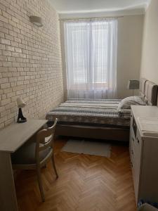 卢布林Zamkowy Apartament的一间卧室配有一张床、一张书桌和一个窗户。