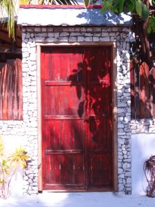 呼拉乎拉日出酒店的一座石墙建筑中的红色门
