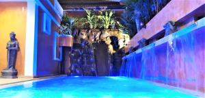 南芭堤雅HIDELAND Luxury Pool Villa Pattaya Walking Street 5 Bedrooms的一座带喷泉的建筑中的游泳池