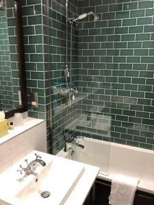 爱丁堡国会大楼酒店的浴室配有水槽、淋浴和浴缸。