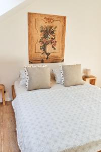 米库洛夫Apartmán NEWSTALGIE的一张带两个枕头的床和墙上的绘画