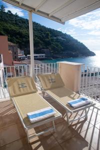 马萨鲁布朗斯Taverna Del Capitano的阳台上配有2把椅子和桌子,俯瞰着水域