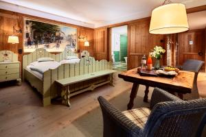 莱赫阿尔贝格Post Lech Arlberg的卧室配有一张床和一张桌子及椅子
