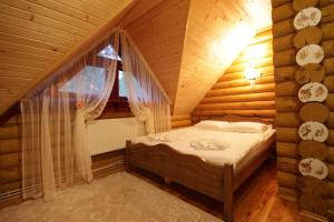亚布卢尼齐亚Еко котедж Яблуницька троянда的木屋内的卧室配有一张床