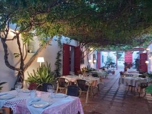 皮萨拉科尔蒂霍德尔艺术酒店 - 卡米尼托德尔雷的一间设有白色桌椅和树木的餐厅