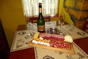 PelluhueAbundia Hotel Boutique de Turismo的一张桌子,上面放着一盘食物和一瓶葡萄酒