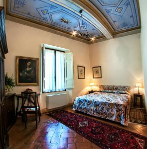 锡耶纳圣卡塔林纳酒店的一间卧室设有一张床和格子天花板