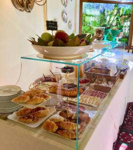 锡耶纳圣卡塔林纳酒店的陈列盒,包括各种糕点和一碗水果