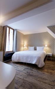特鲁瓦Appart'Hôtel Sainte Trinité的卧室设有一张白色大床和一扇窗户。