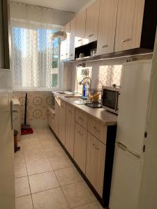 IgnatievoКъща Спирови的厨房配有木制橱柜和白色冰箱。