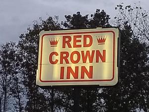 罗瑞尔Red Crown Inn的红冠旅馆标志在一些树前