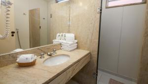 里约热内卢Rede Andrade Canada的浴室配有盥洗盆、镜子和毛巾