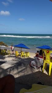 拉巴拉德纳圣米格尔ILOA Residence Apt Completo的海滩上设有椅子和遮阳伞,还有大海