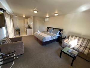 基督城Delago Motel/Apartments的酒店客房,配有床和沙发