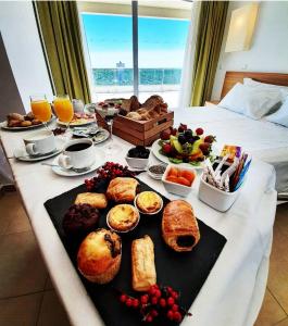 蒙蒂戈杜蒙特格都公寓温泉酒店的床上的早餐桌,包括面包和其他食物