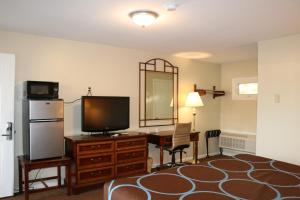 MoosupElite Inn的酒店客房配有带电视和镜子的书桌