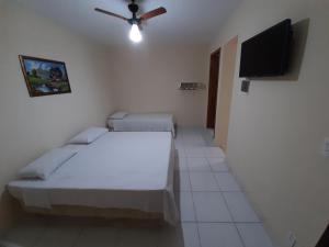 阿帕雷西达Pousada Pena的客房设有两张床和一台平面电视。