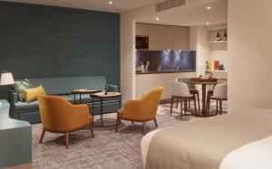 希灵登Staybridge Suites London Heathrow - Bath Road, an IHG Aparthotel的酒店客房配有一张床、一张沙发和椅子。
