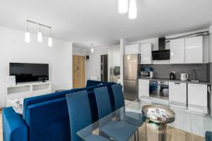 波兹南Sleepway Apartments - Strzelecka 29A-15的客厅配有蓝色的沙发和玻璃桌