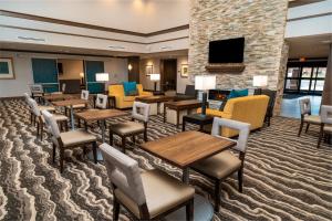 拉戈Staybridge Suites - Washington DC East - Largo, an IHG Hotel的酒店客房设有桌椅和壁炉。