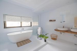 台南明洞的白色的浴室设有浴缸和两个盥洗盆