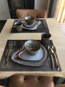 ManhayBeau Réveil nature & wellness - gite 1的一张木桌,上面有三个碗和盘子