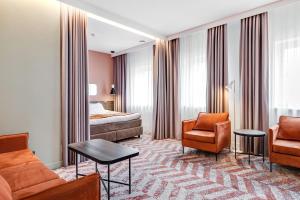 考纳斯考那斯酒店的酒店客房,配有床、沙发和椅子